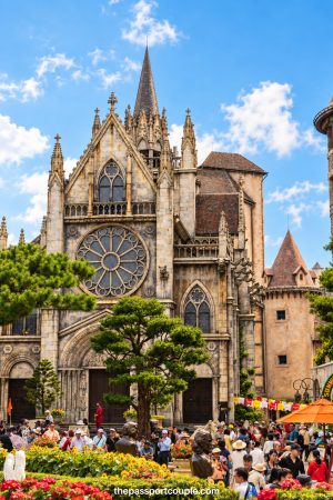 1 week in Vietnam itinerary featuring Ba Na Hills and the Golden Bridge, with a stunning Gothic style French inspired church surrounded by colorful flowers and visitors.